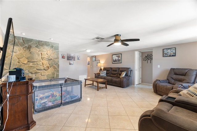 tiled living room featuring a fireplace and ceiling fan