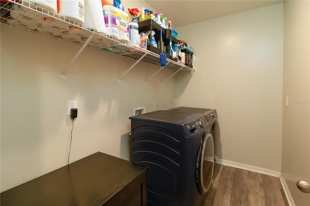 11134 Horned Owl Rd, Weeki Wachee, FL 34614 - clothes washing area with washing machine and clothes dryer, baseboards, wood finished floors, and laundry area