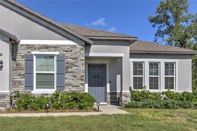 11134 Horned Owl Rd, Weeki Wachee, FL 34614 - property entrance with stucco siding, roof with shingles, and stone siding