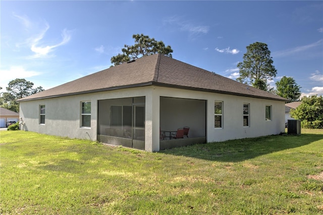 11134 Horned Owl Rd, Weeki Wachee, FL 34614 - rear view of house featuring a lawn, roof with shingles, central AC, and stucco siding