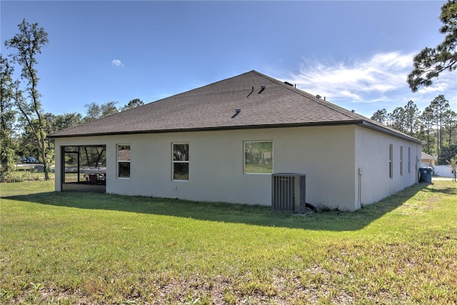 11134 Horned Owl Rd, Weeki Wachee, FL 34614 - back of property with a lawn, a shingled roof, central AC, and stucco siding