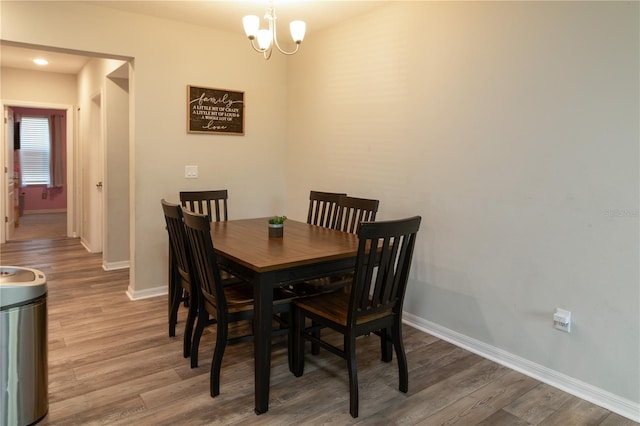 11134 Horned Owl Rd, Weeki Wachee, FL 34614 - dining space with a chandelier, wood finished floors, and baseboards