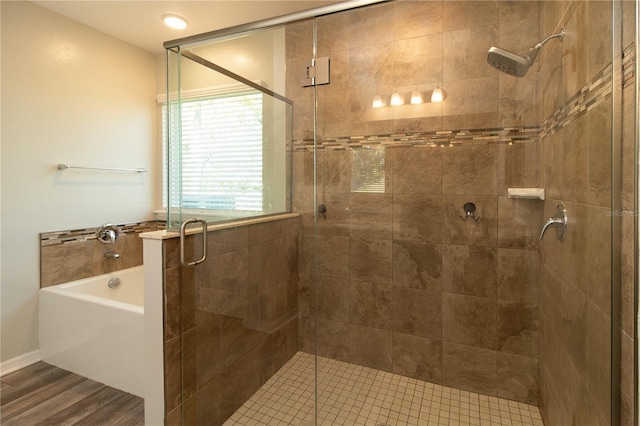 11134 Horned Owl Rd, Weeki Wachee, FL 34614 - bathroom featuring a bath, a stall shower, and wood finished floors