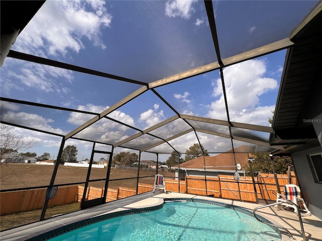 view of swimming pool with glass enclosure, a patio area, a fenced backyard, and a fenced in pool