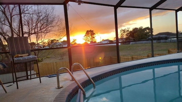 pool at dusk with a patio, fence, a lanai, and an outdoor pool