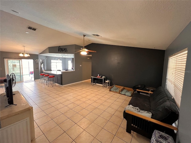 living room with light tile patterned floors, visible vents, vaulted ceiling, and ceiling fan with notable chandelier