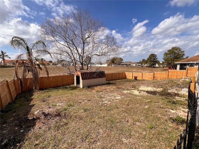 view of yard with a fenced backyard, an outdoor structure, and a shed