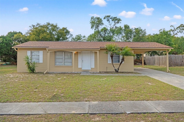 ranch-style house featuring fence, an attached carport, concrete driveway, and a front yard