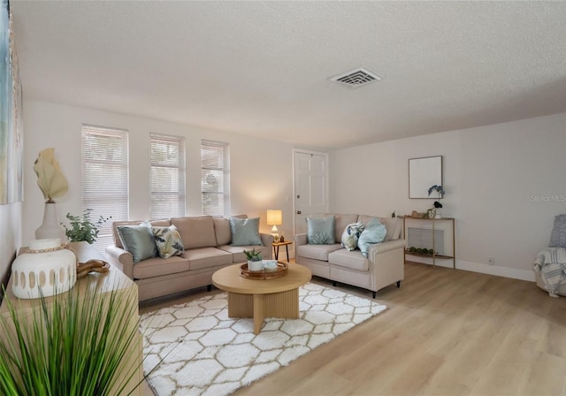 living room featuring a textured ceiling and light wood-type flooring