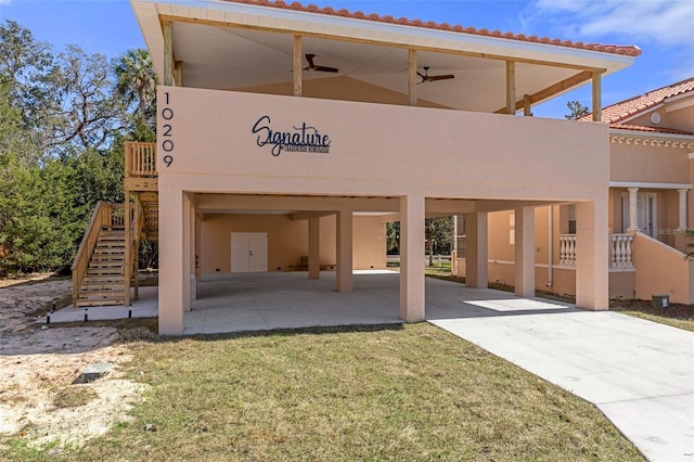 back of property with ceiling fan and a lawn