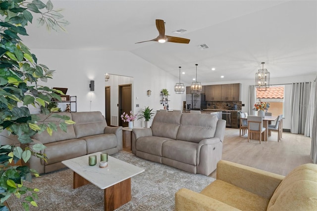 living room with lofted ceiling, ceiling fan with notable chandelier, beverage cooler, and light wood-type flooring