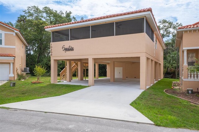 10209 W Waterlander Loop Unit 164, Homosassa, FL 34448 - view of front facade featuring a carport, a sunroom, concrete driveway, and stucco siding