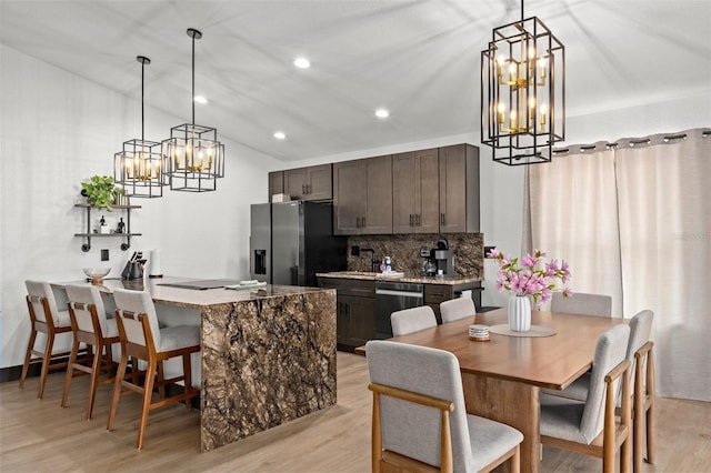 10209 W Waterlander Loop Unit 164, Homosassa, FL 34448 - kitchen featuring stainless steel appliances, dark brown cabinetry, backsplash, a chandelier, and light wood-type flooring