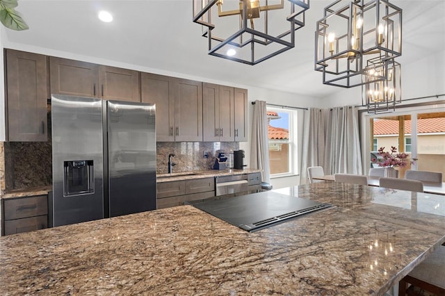 10209 W Waterlander Loop Unit 164, Homosassa, FL 34448 - kitchen featuring stainless steel appliances, a chandelier, backsplash, dark brown cabinetry, and dark stone countertops