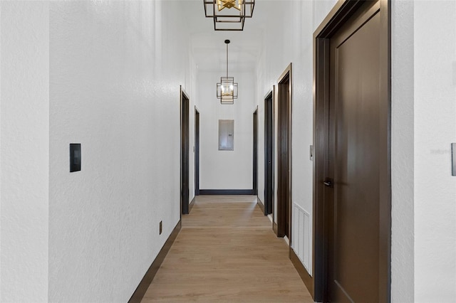 10209 W Waterlander Loop Unit 164, Homosassa, FL 34448 - corridor featuring a chandelier, a textured wall, light wood-type flooring, and electric panel