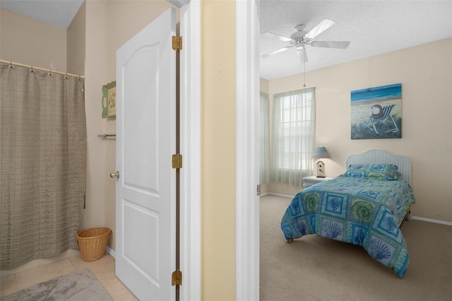 tiled bedroom featuring ceiling fan and a textured ceiling