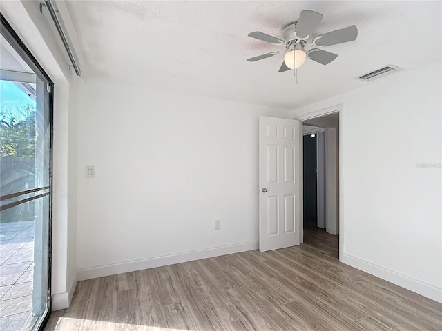 spare room featuring ceiling fan, a textured ceiling, and light hardwood / wood-style flooring