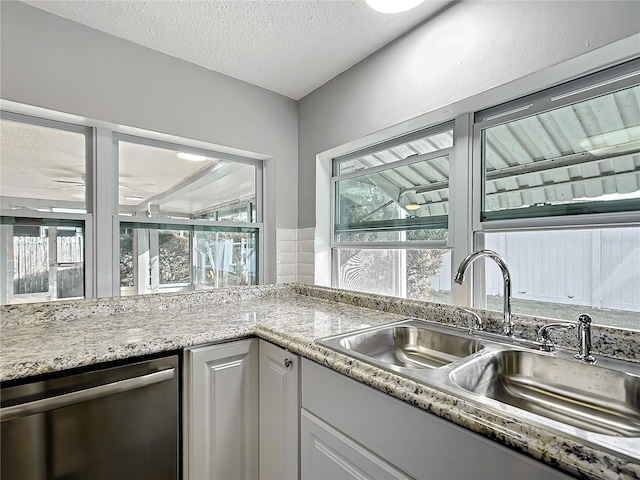 kitchen with white cabinetry, sink, a textured ceiling, and dishwasher