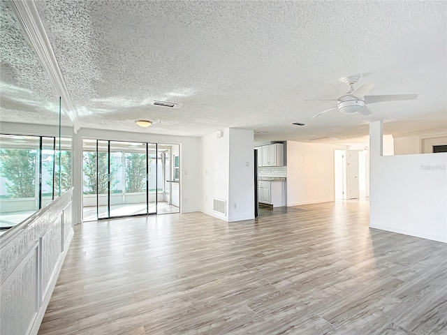 empty room featuring ceiling fan, a textured ceiling, and light wood-type flooring