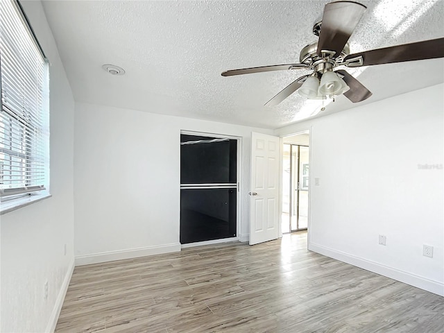 spare room featuring ceiling fan, a textured ceiling, and light hardwood / wood-style flooring