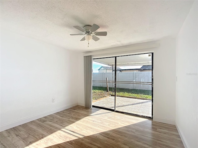 spare room featuring ceiling fan, a textured ceiling, and light wood-type flooring