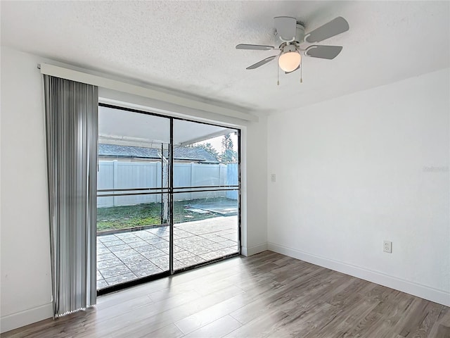 empty room featuring hardwood / wood-style floors, a textured ceiling, and ceiling fan