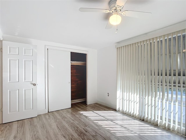 unfurnished bedroom with light hardwood / wood-style floors, a closet, and ceiling fan