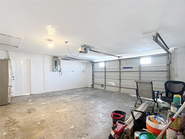 garage with a garage door opener, stainless steel fridge, and electric panel