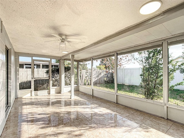 unfurnished sunroom featuring ceiling fan