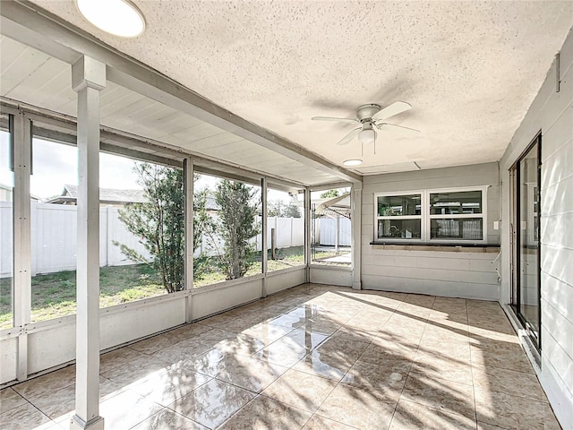 unfurnished sunroom with ceiling fan