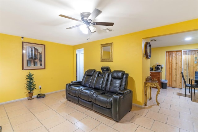 tiled home theater room with ceiling fan