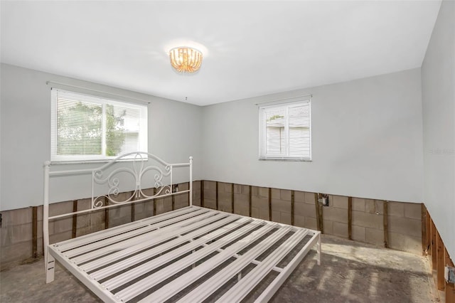 unfurnished bedroom with multiple windows and concrete floors