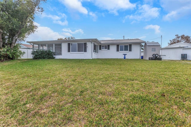 rear view of property with cooling unit and a yard