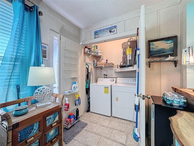 laundry room featuring electric water heater, a textured ceiling, washer and dryer, laundry area, and electric panel