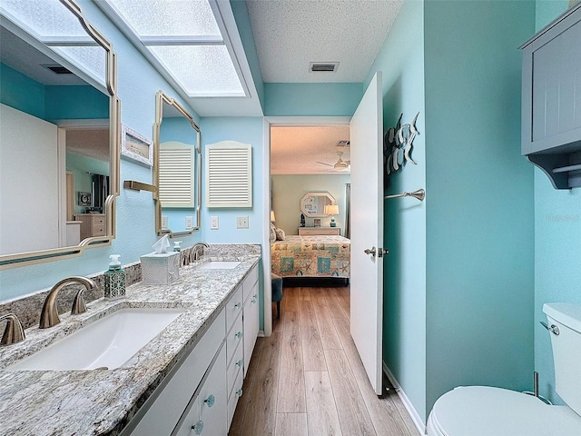 bathroom featuring visible vents, wood finished floors, a sink, and toilet