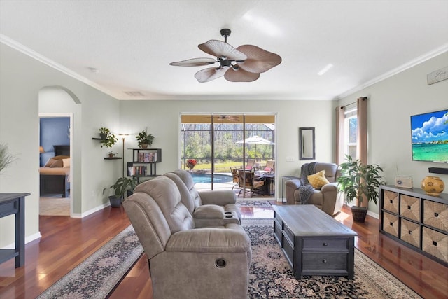 living area with arched walkways, wood finished floors, and a healthy amount of sunlight