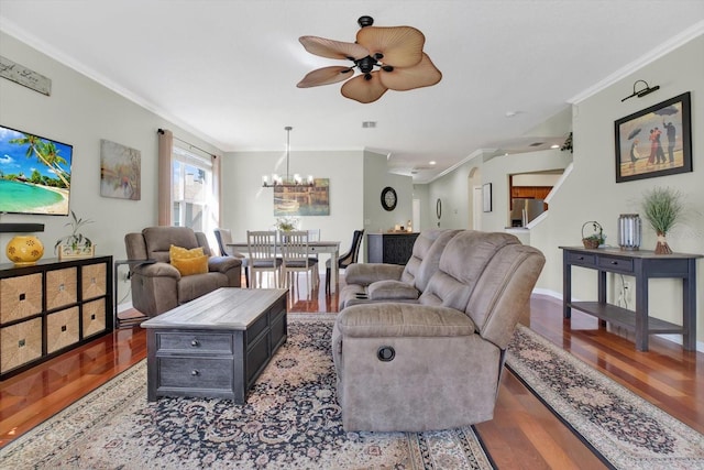 living area featuring ceiling fan with notable chandelier, crown molding, baseboards, and wood finished floors