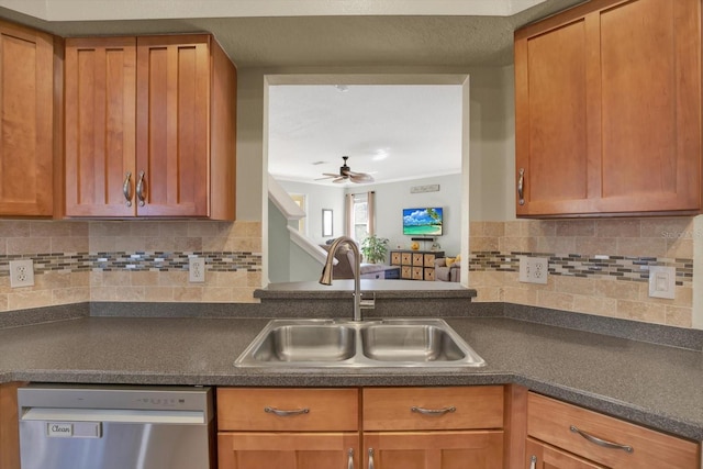 kitchen featuring dark countertops, decorative backsplash, stainless steel dishwasher, brown cabinetry, and a sink