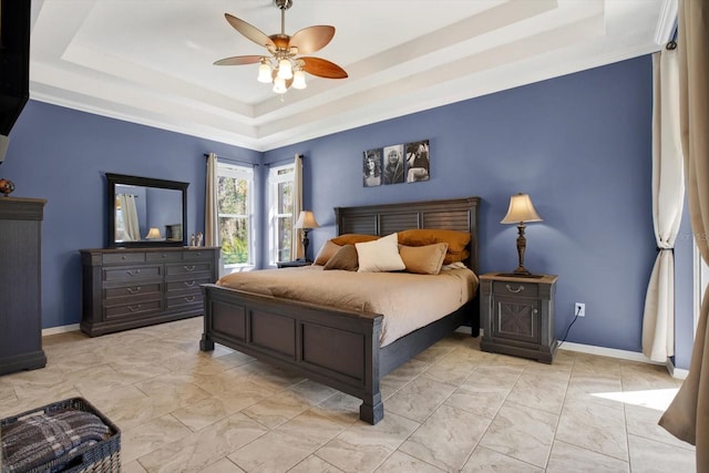 bedroom with ceiling fan, a raised ceiling, and baseboards