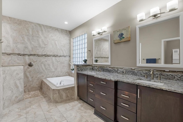 bathroom featuring marble finish floor, double vanity, a sink, and a bath