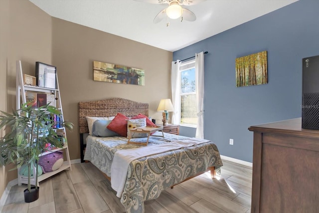 bedroom featuring baseboards, a ceiling fan, and wood tiled floor