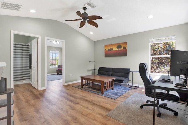 office space featuring lofted ceiling, ceiling fan, light wood-type flooring, and visible vents