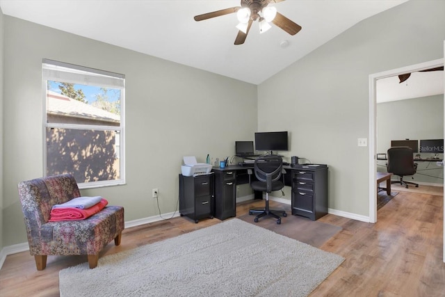 office space with vaulted ceiling, a ceiling fan, light wood-style flooring, and baseboards