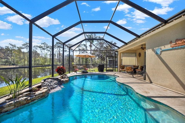 outdoor pool featuring glass enclosure and a patio