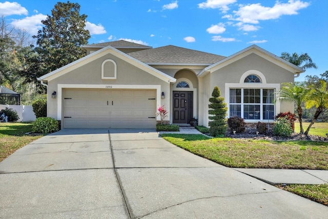 ranch-style home with a front yard, driveway, an attached garage, and stucco siding