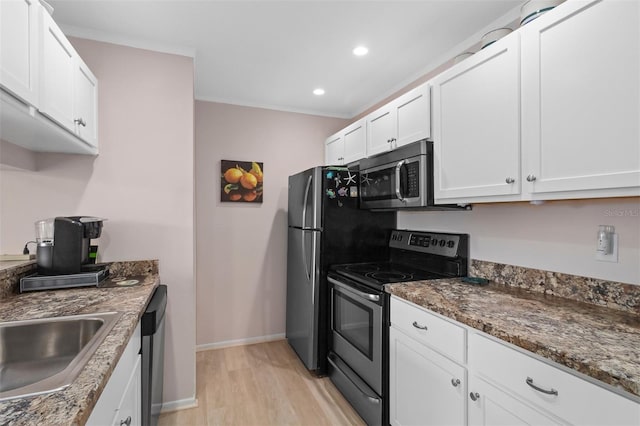 kitchen featuring white cabinetry, sink, dark stone countertops, stainless steel appliances, and light hardwood / wood-style flooring