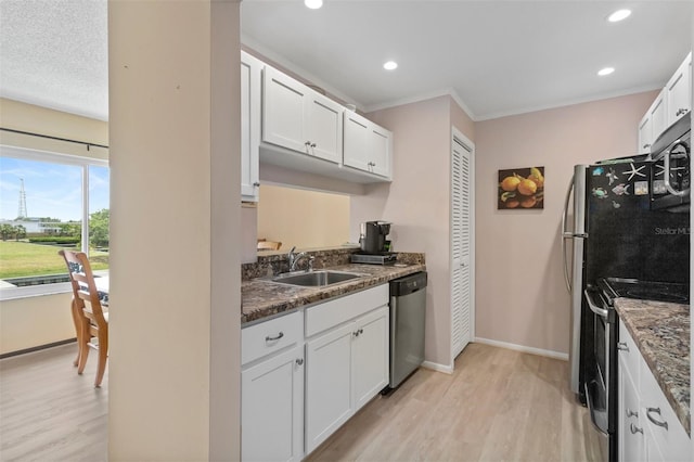 kitchen featuring sink, dark stone counters, white cabinets, and appliances with stainless steel finishes