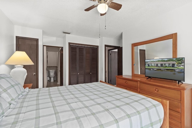 bedroom featuring ceiling fan, a textured ceiling, and two closets