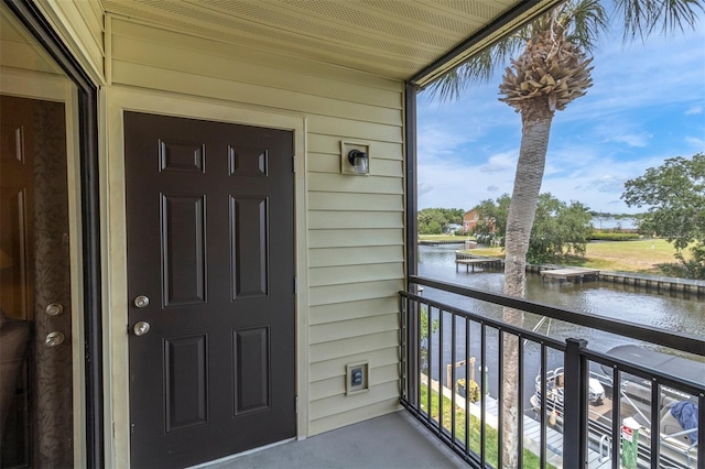 property entrance with a water view and a balcony