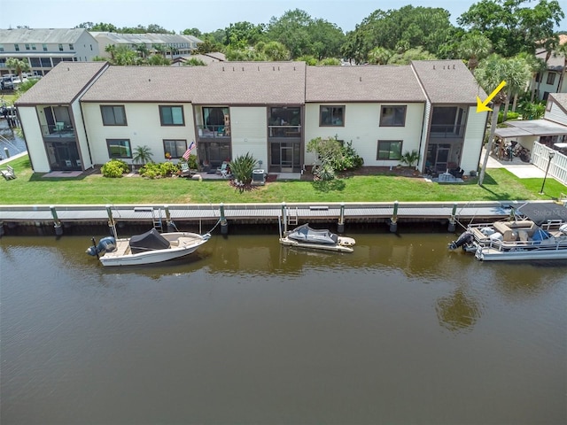 rear view of property featuring a water view and a yard